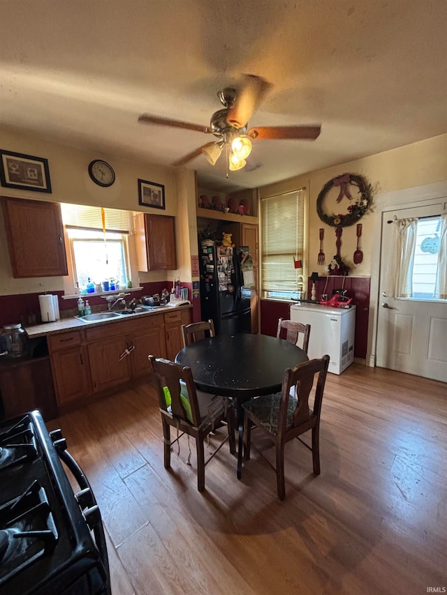 dining area featuring a ceiling fan and light wood-style floors