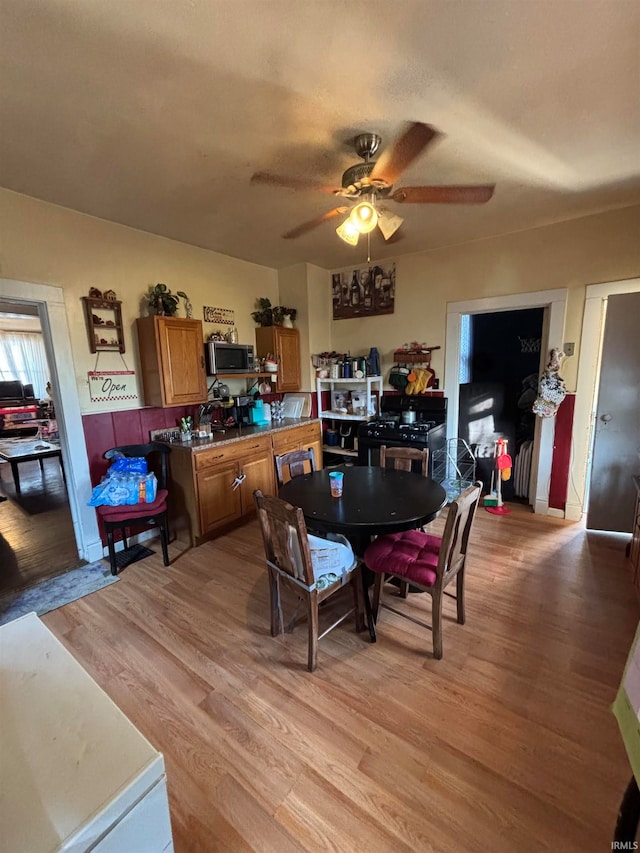 dining space featuring light wood-style flooring and ceiling fan