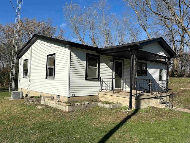 view of front of property with covered porch, central air condition unit, and a front yard