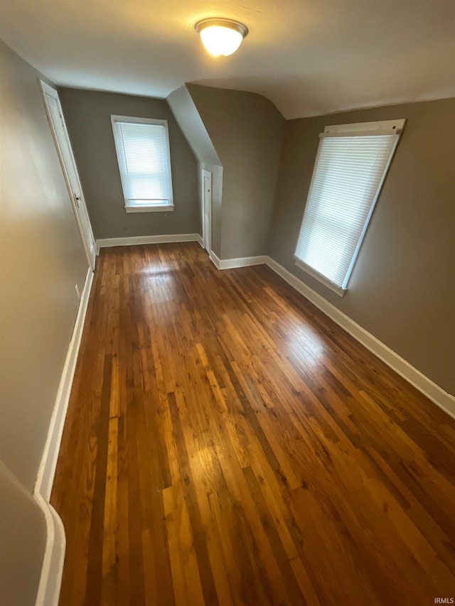 bonus room with dark wood-type flooring and lofted ceiling