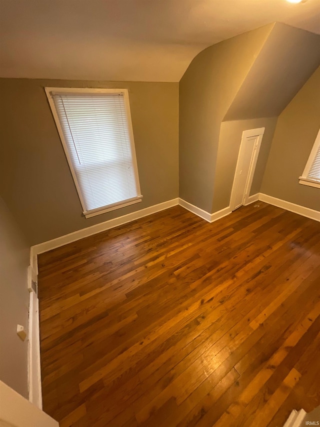 bonus room with dark hardwood / wood-style flooring and lofted ceiling