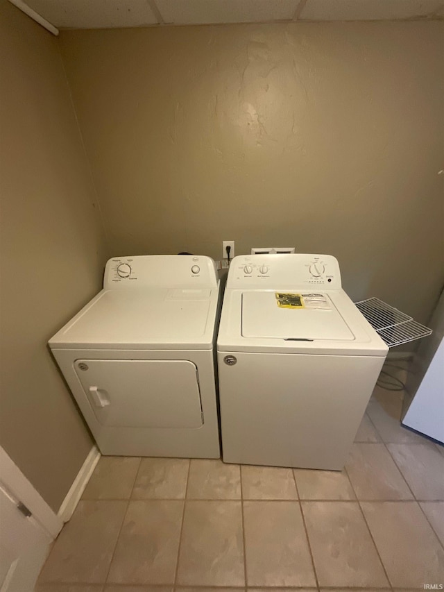 clothes washing area with light tile patterned floors and washing machine and clothes dryer