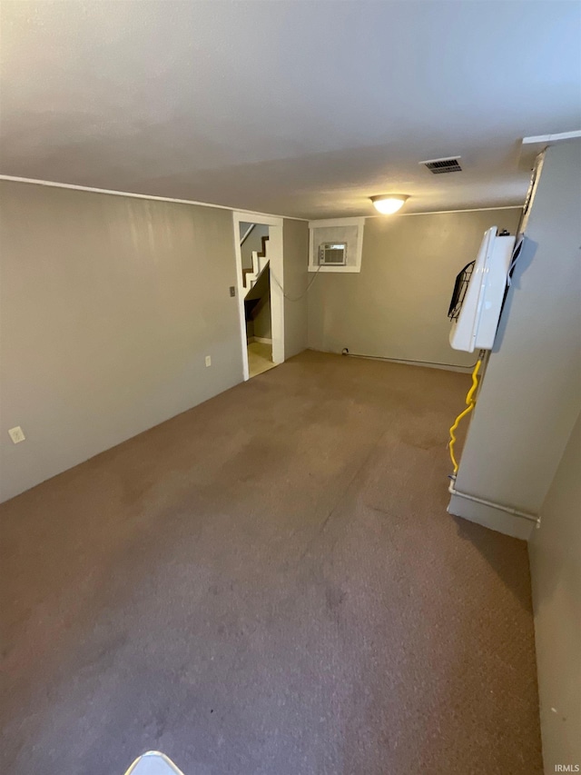 basement featuring carpet flooring and an AC wall unit