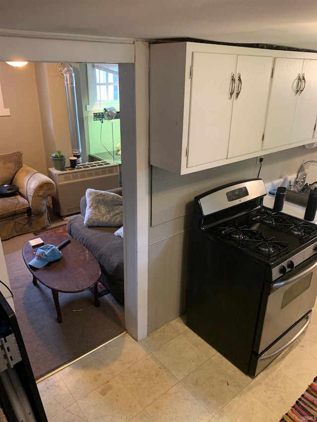 kitchen with stainless steel gas stove and white cabinetry