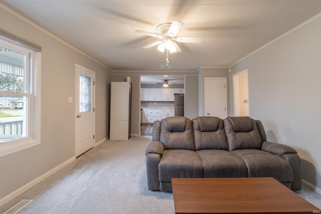 carpeted living room with ceiling fan and ornamental molding