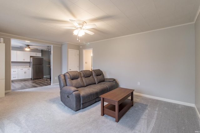 carpeted living room with ceiling fan and crown molding