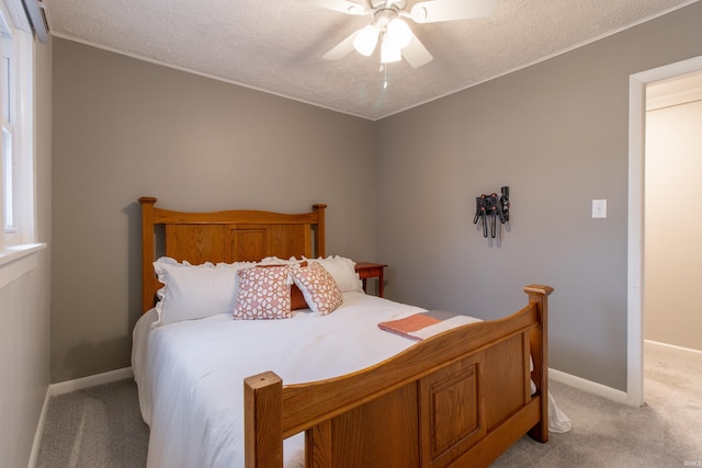 carpeted bedroom with ceiling fan and a textured ceiling