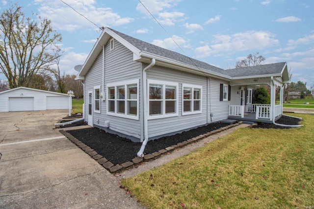 view of side of home featuring a garage, a yard, and an outbuilding