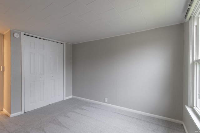 unfurnished bedroom with a closet, carpet floors, and multiple windows