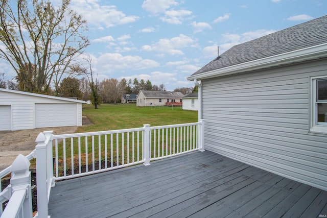 wooden deck featuring a lawn, an outdoor structure, and a garage