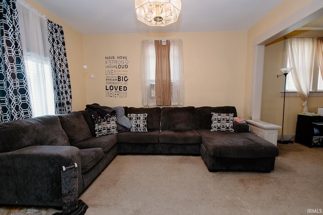 carpeted living room featuring a chandelier