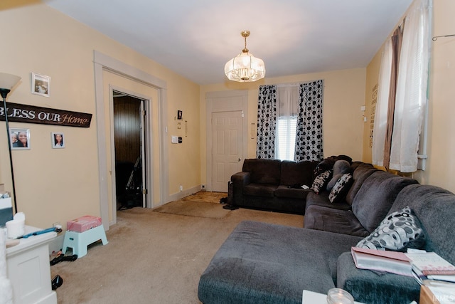 carpeted living room with a chandelier