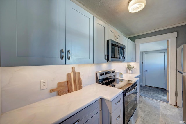 kitchen with a textured ceiling, stainless steel appliances, and backsplash