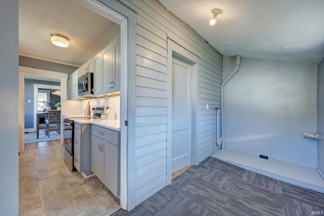 kitchen featuring tasteful backsplash, wood walls, and stainless steel appliances