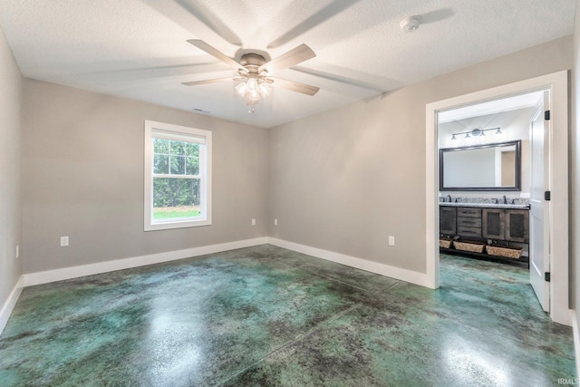 empty room with ceiling fan and a textured ceiling