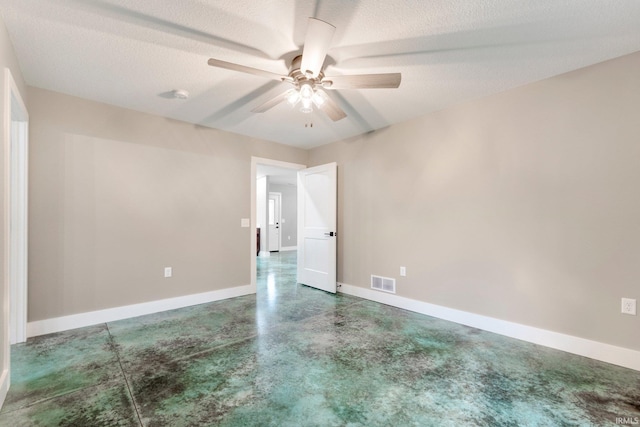 empty room with ceiling fan and a textured ceiling