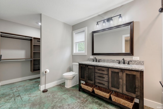 bathroom featuring vanity, a textured ceiling, and toilet