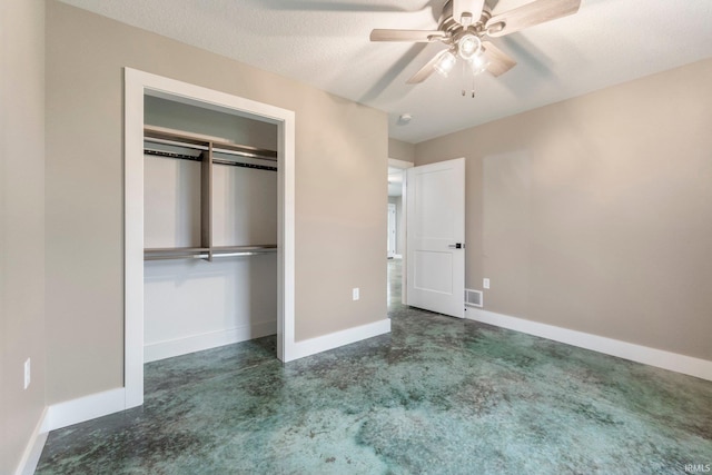 unfurnished bedroom featuring dark colored carpet, a textured ceiling, a closet, and ceiling fan