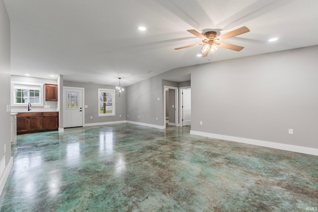 unfurnished living room with a textured ceiling, ceiling fan with notable chandelier, and sink