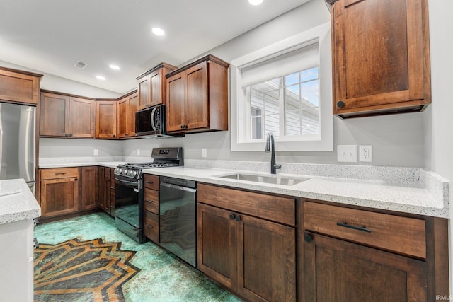 kitchen featuring light stone counters, sink, and black appliances