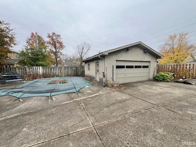 view of side of property featuring a garage and a covered pool