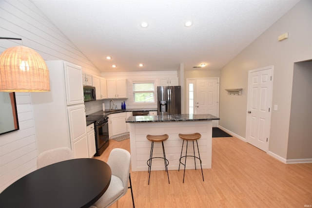 kitchen featuring sink, black appliances, light hardwood / wood-style flooring, white cabinets, and lofted ceiling