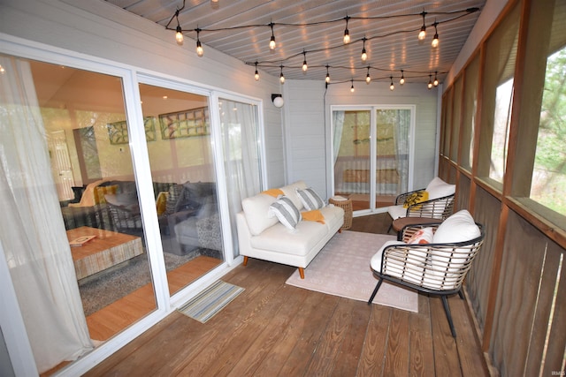 sunroom / solarium featuring track lighting and plenty of natural light