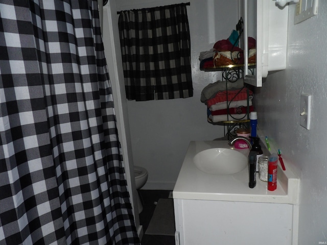 bathroom featuring curtained shower, vanity, and toilet