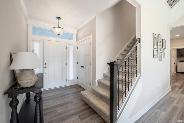 entrance foyer featuring crown molding, a notable chandelier, and hardwood / wood-style flooring