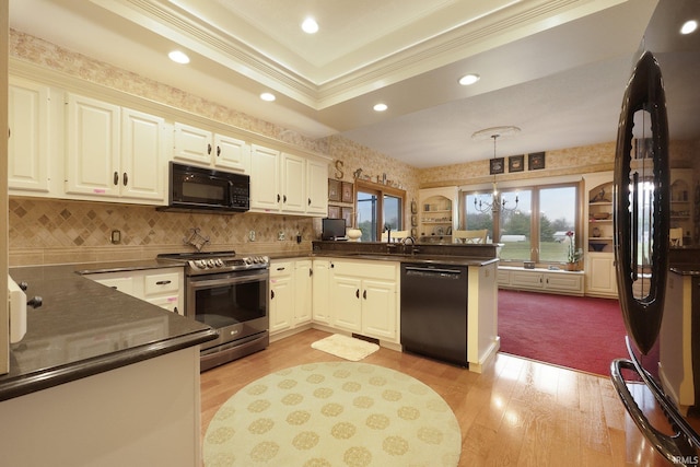 kitchen featuring black appliances, white cabinets, hanging light fixtures, light hardwood / wood-style flooring, and kitchen peninsula