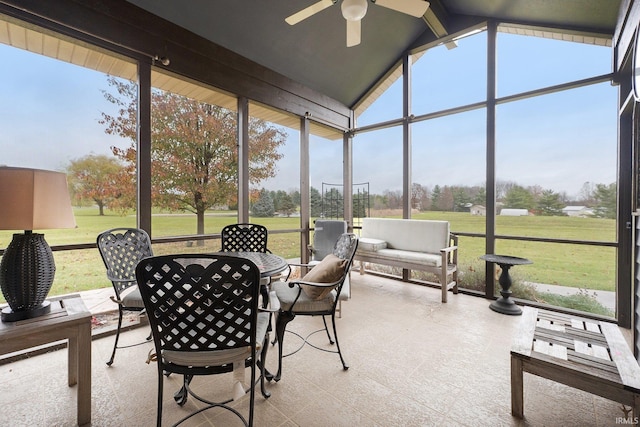 sunroom / solarium with ceiling fan, plenty of natural light, and lofted ceiling with beams