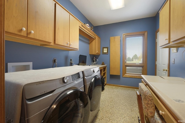 clothes washing area with washer and dryer and cabinets