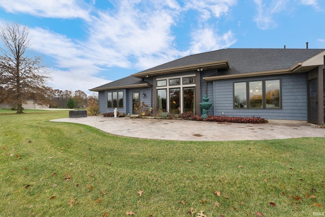 rear view of property with a lawn and a patio