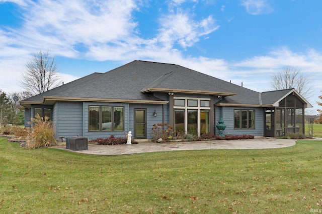 rear view of property with a yard, a patio area, and a sunroom