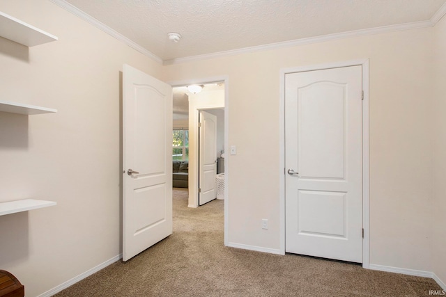 unfurnished bedroom featuring light colored carpet, ornamental molding, and a textured ceiling