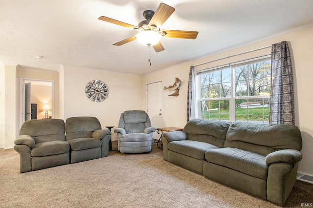 carpeted living room featuring ceiling fan and a textured ceiling