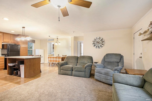 living room with light wood-type flooring, ceiling fan, and crown molding