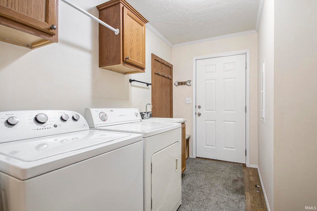 washroom featuring sink, cabinets, a textured ceiling, washer and clothes dryer, and ornamental molding