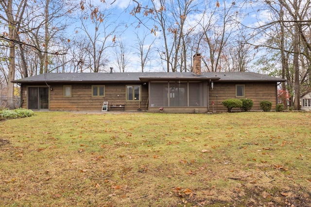 back of property with a sunroom and a yard