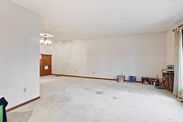 empty room featuring carpet flooring and a chandelier