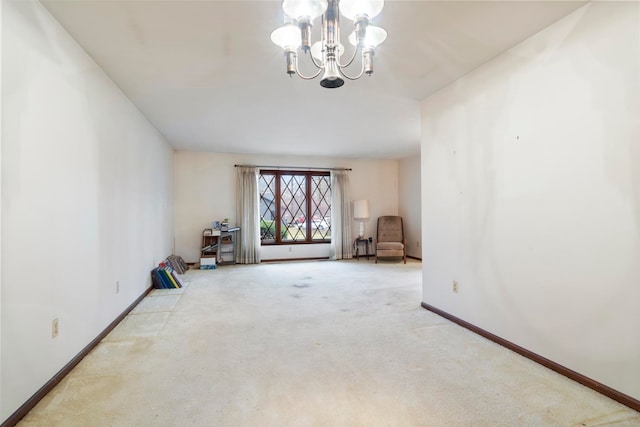 carpeted spare room featuring an inviting chandelier