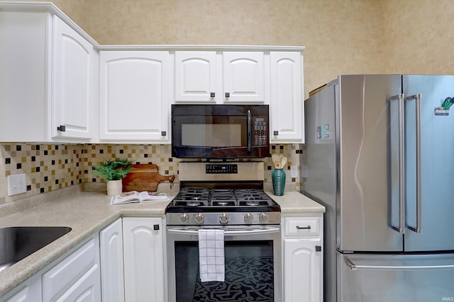 kitchen with sink, white cabinetry, backsplash, and appliances with stainless steel finishes