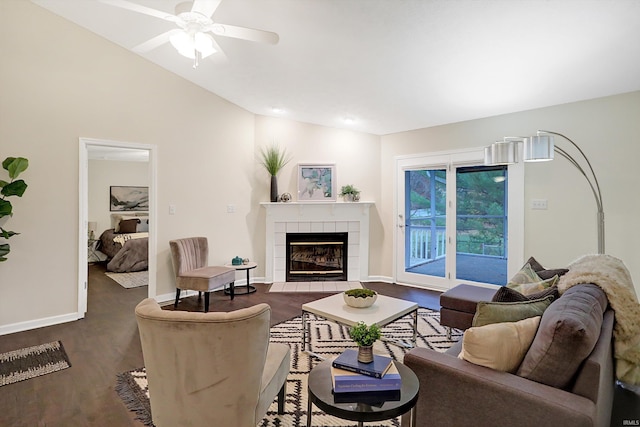 living room with ceiling fan, a fireplace, and vaulted ceiling