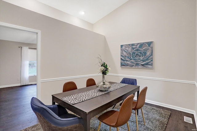 dining space featuring lofted ceiling and dark hardwood / wood-style floors