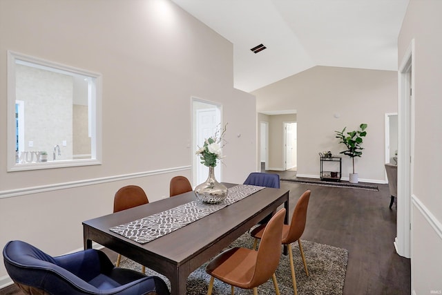 dining room featuring high vaulted ceiling, a wealth of natural light, and dark wood-type flooring