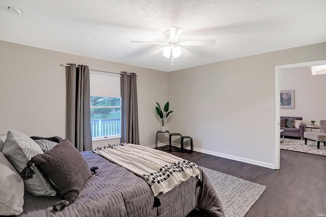 bedroom with a textured ceiling, ceiling fan, and dark wood-type flooring