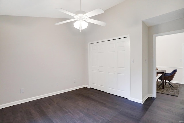 unfurnished bedroom featuring lofted ceiling, a closet, dark wood-type flooring, and ceiling fan