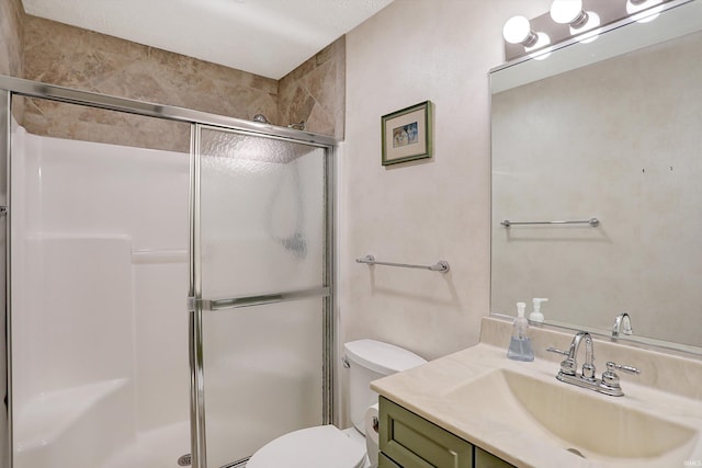 bathroom featuring vanity, toilet, and a shower with shower door