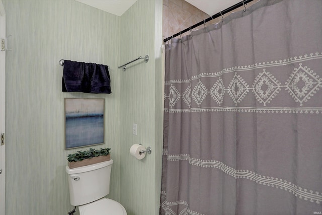 bathroom featuring curtained shower and toilet