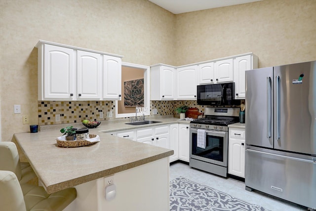 kitchen with kitchen peninsula, a kitchen breakfast bar, stainless steel appliances, and sink